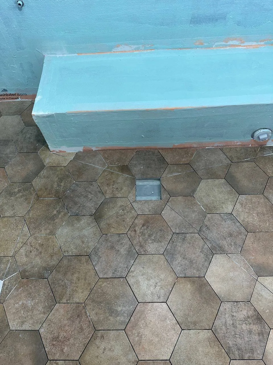 Stone-look hexagon tile laid across the wet room floor and up over the formed benches