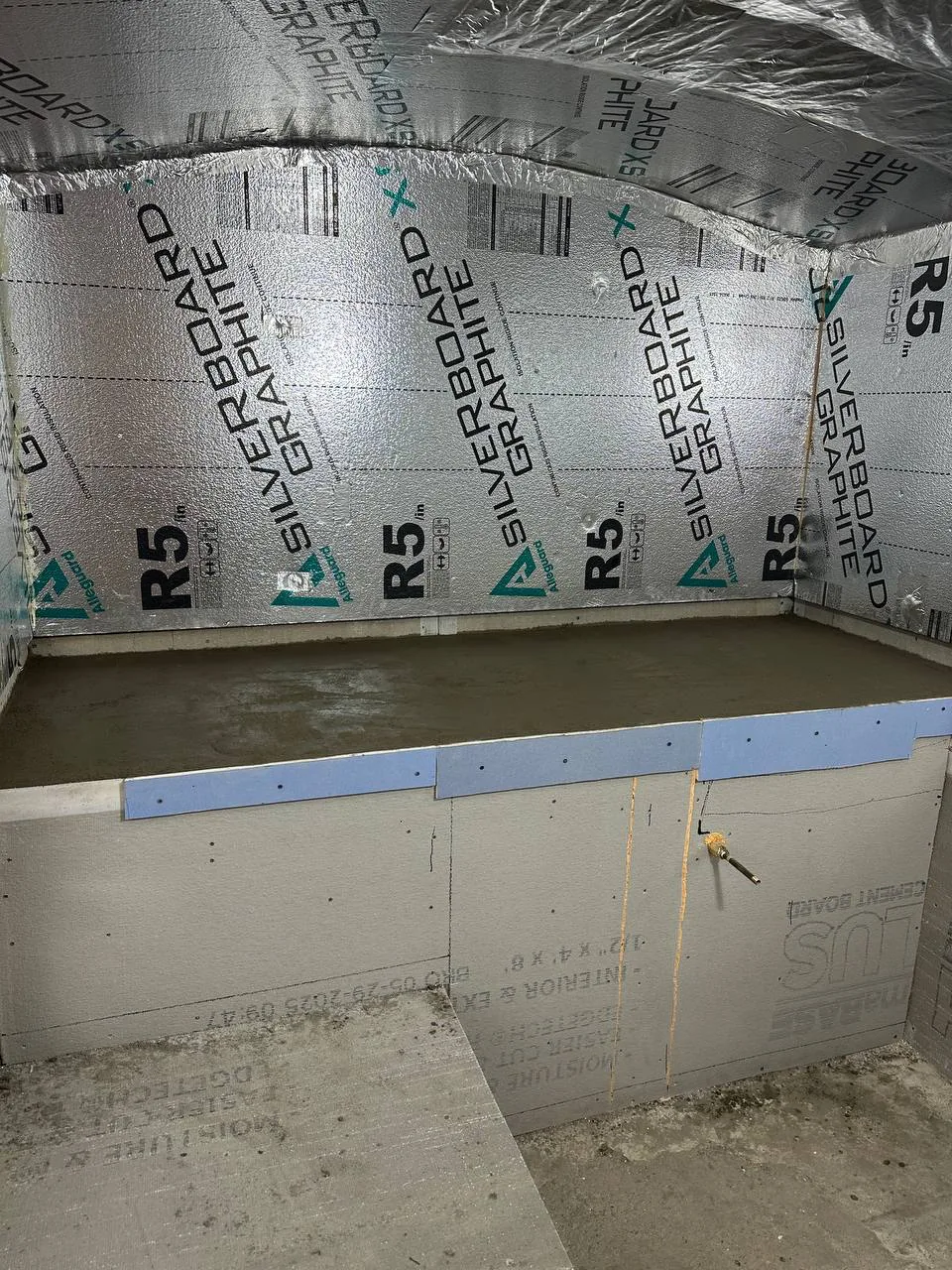 Basement dug out and lined with rigid insulation board before a new slab is poured