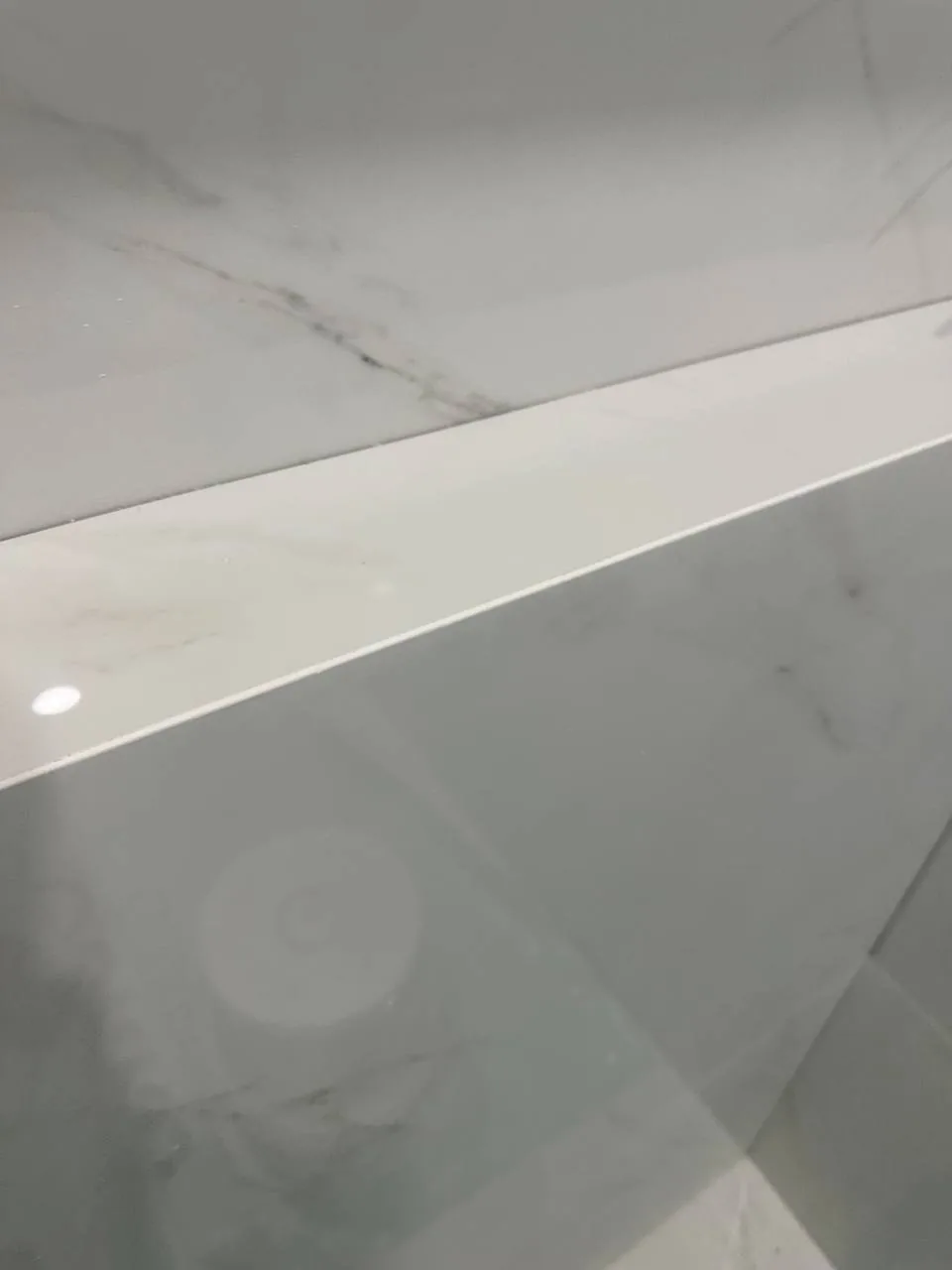 Mitred external corner on a marble-look porcelain step, joint closed to a hairline