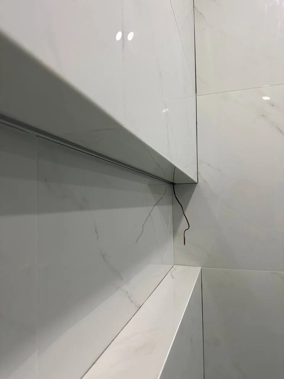 Mitred corner detail on a large-format porcelain wall where the slab turns a right angle