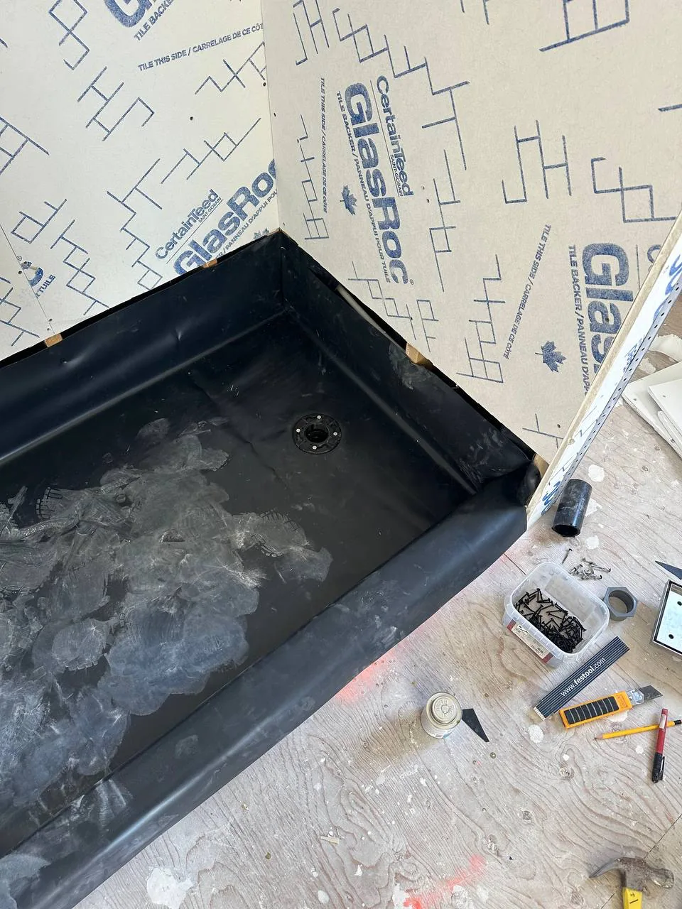 Black PVC shower pan liner dressed up the walls with the corner folded rather than cut