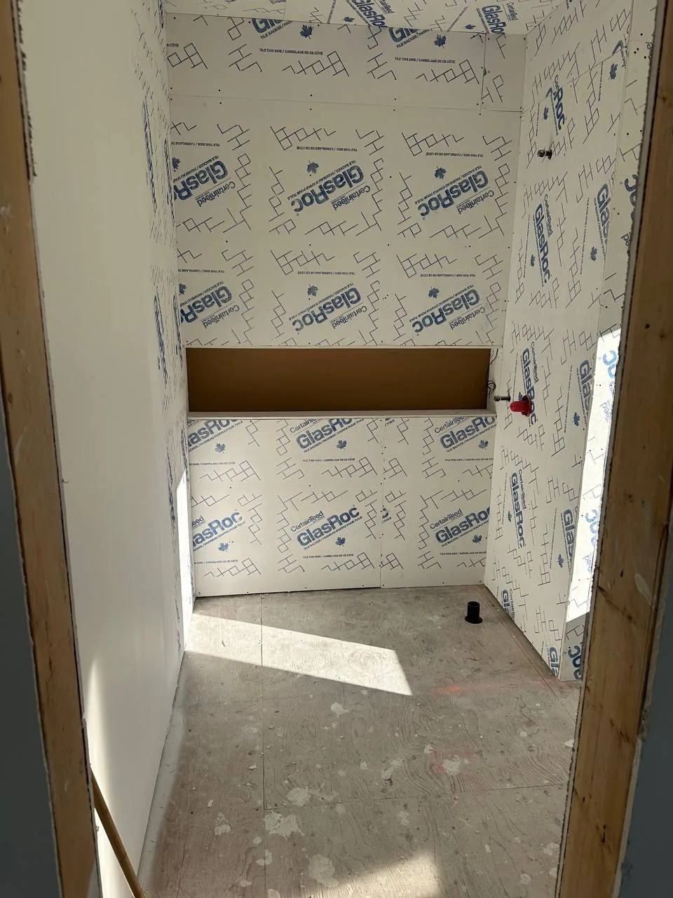 Shower walls sheeted in glass-mat gypsum board with the niche opening framed out